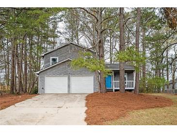 Charming two-story home featuring a blue front door and a two-car garage at 3201 Palomino Dr, Powder Springs, GA 30127