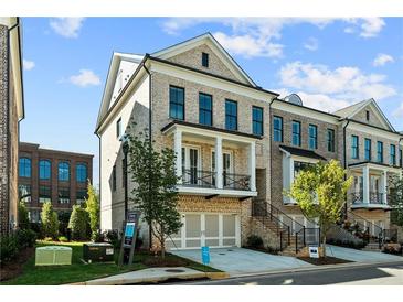 Beautiful brick townhome with a metal roof, second story balcony, and a two car garage at 235 Briscoe Way # 7, Alpharetta, GA 30009