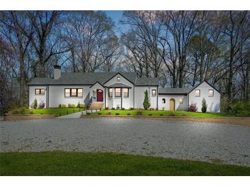 Charming white-painted brick home with a manicured lawn and a gravel driveway at 4900 College St, Union City, GA 30291