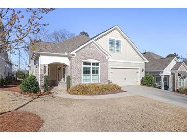 Charming home featuring brick accents, a well-manicured lawn, and an attached garage at 1011 Stillington Way, Kennesaw, GA 30152