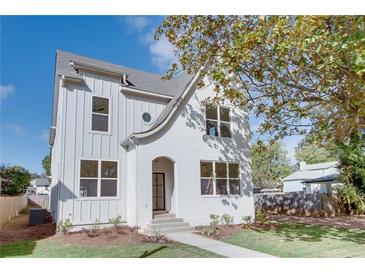 Charming white brick two-story home with landscaped front yard and black framed windows at 3395 Lee St, East Point, GA 30344