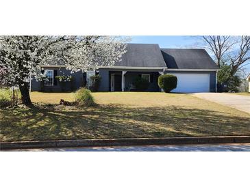 Charming one-story home with blooming tree, well-maintained lawn, and attached two-car garage at 75 Doves Nest, Covington, GA 30016