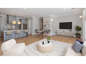 Open-concept living room featuring hardwood floors, modern decor, kitchen, and adjacent dining area at 281 15Th Ne St # 101, Atlanta, GA 30309