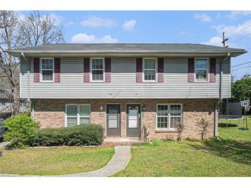 Traditional two-story duplex featuring brick facade and neutral siding at 1143 Forest Villa Nw Dr, Conyers, GA 30012
