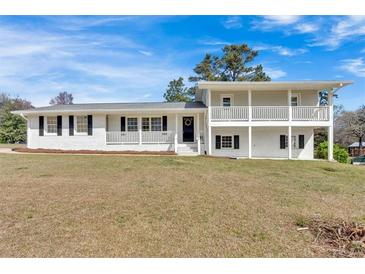Charming two-story home with a white brick exterior and a lovely front porch at 3679 Mill Glen Dr, Douglasville, GA 30135
