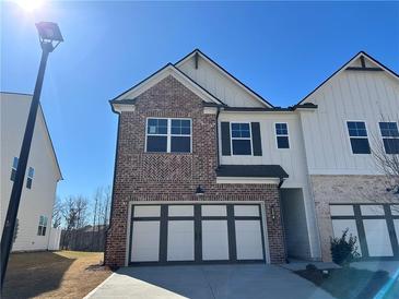 Charming two-story home featuring a brick facade, two-car garage, and modern architectural details at 254 Depot Landing Rd # 55, Auburn, GA 30011