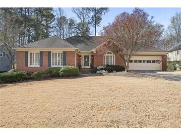 Charming brick ranch-style home with lush landscaping and an attached two-car garage at 549 Trailwood Sw Ln, Marietta, GA 30064