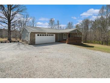 Charming single-story home featuring a stone facade and a spacious driveway leading to an attached two-car garage at 1875 Ebenezer Sw Rd, Conyers, GA 30094