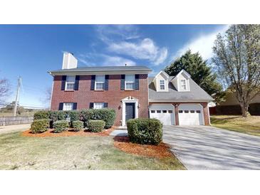Charming brick home featuring a two-car garage and well-maintained front yard at 921 Dunagan Way, Lawrenceville, GA 30045
