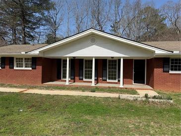 Charming brick ranch-style home with black shutters and a welcoming covered front porch at 3153 Lake Monroe Rd, Douglasville, GA 30135