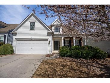 Charming white home featuring a well-manicured lawn and blooming tree at 1555 Diplomat Dr, Cumming, GA 30041