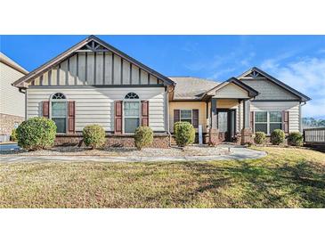 Charming home showcasing a well-manicured lawn, stylish windows and a cozy porch with decorative columns at 20 Gentle Spring Ln, Covington, GA 30016