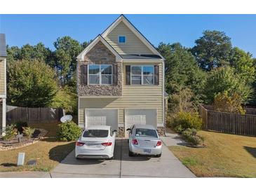 Charming two-story home with stone accents and a two-car garage, nestled in a well-maintained community at 4050 Ironwood Dr, Atlanta, GA 30349