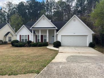Charming home featuring a landscaped front yard, a two-car garage, and a columned front porch at 950 Spring Ives Dr, Lawrenceville, GA 30043