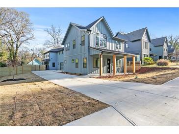 Modern two-story home with a covered front porch and a long driveway on a sunny day at 1247 Bridges Sw Ave # B, Atlanta, GA 30310