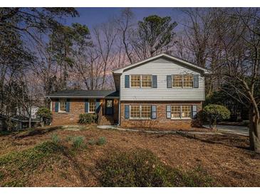 Charming two-story home featuring a brick facade, blue shutters, and a well-maintained front yard at 1677 Foresta Ct, Atlanta, GA 30341