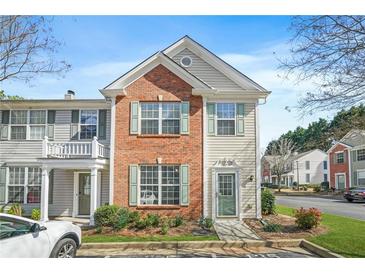 Charming brick and siding townhome with a well-manicured front yard and a welcoming entrance at 4645 Valais Ct # 135, Alpharetta, GA 30022