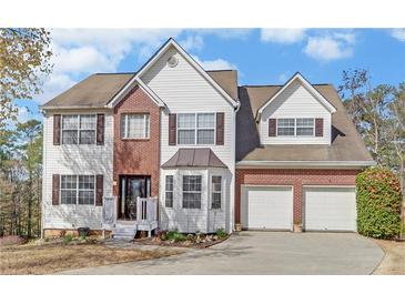 Charming two-story home with a combination of brick and white siding plus an attached two-car garage at 3000 Gallery Walk, Snellville, GA 30039