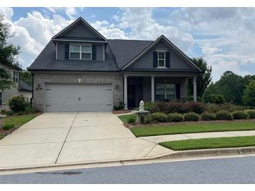 Charming brick home with a manicured lawn, two-car garage, and a welcoming front entrance at 310 Ellington Dr, Canton, GA 30115