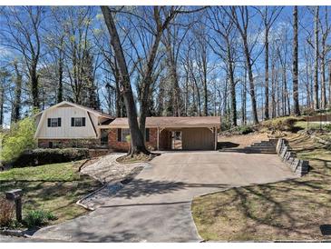 Charming exterior showcasing a well-maintained home with a spacious driveway and a convenient covered parking area at 3334 Spring Meadow Ct, Tucker, GA 30084