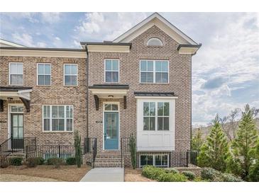 Beautiful brick exterior of a two-story townhome with a blue front door and manicured landscaping at 4565 Sims Park Overlook, Suwanee, GA 30024