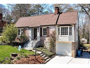 Charming brick home featuring landscaped front yard, gabled roof, and attached one-car garage at 2795 Kimmeridge Dr, Atlanta, GA 30344