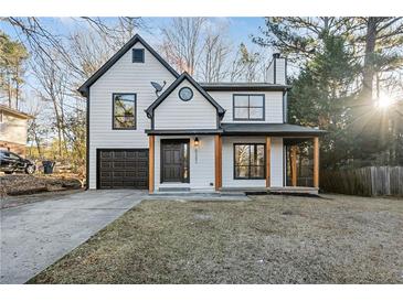 Charming two-story home with a front porch, garage, and manicured lawn at 6382 Revena Dr, Morrow, GA 30260
