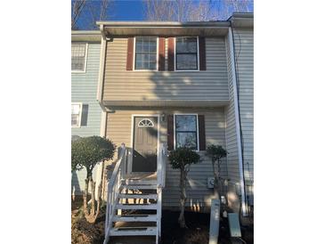 Charming townhouse with a welcoming entrance, featuring well-maintained siding and front steps at 7042 Oakhill Cir, Austell, GA 30168
