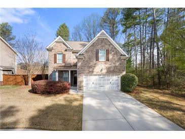 Charming two-story brick home features a well-manicured lawn and an attached two-car garage at 830 Nottingham Se Dr, Smyrna, GA 30082