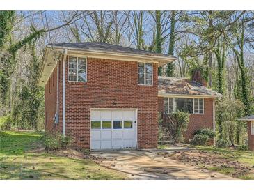 Charming brick home featuring an attached garage and mature trees in a serene setting at 195 Hermer Nw Cir, Atlanta, GA 30311