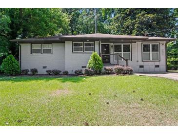 Charming one-story home with gray brick, updated windows, manicured lawn, and mature trees at 3021 San Juan Dr, Decatur, GA 30032