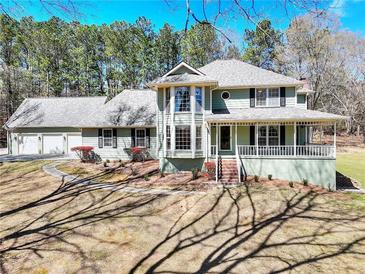 Charming two-story home featuring a spacious porch, beautiful windows, and an attached three car garage at 4130 Plunkett Rd, Lithonia, GA 30038