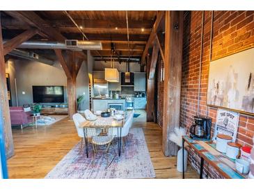 Open-concept dining room with exposed brick, wooden beams, and stylish furnishings at 490 Marietta Nw St # 101, Atlanta, GA 30313