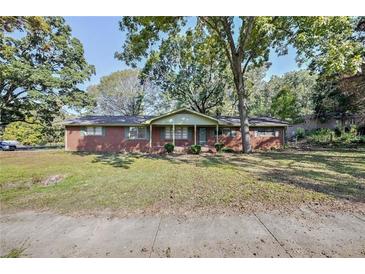 Charming single-story brick home with a well-maintained lawn and mature trees at 1189 E East Fayetteville Rd, Riverdale, GA 30296