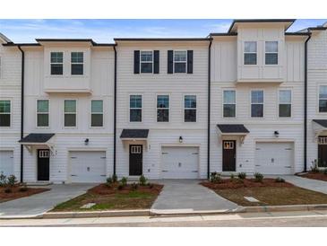 Newly built townhomes feature a white exterior, multiple windows, and a one car garage at 3135 Washburn St, Atlanta, GA 30354