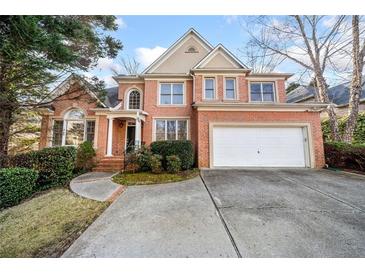Charming two-story brick home with attached two-car garage and well-manicured landscaping at 5071 Vinings Estates Se Ct, Mableton, GA 30126