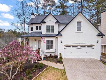 Charming two-story home with a two-car garage and a lovely magnolia tree in the front yard at 303 Valley Green Ct, Woodstock, GA 30189
