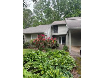 Charming home exterior featuring colorful landscaping and neutral siding for a welcoming curb appeal at 165 Woodhaven Way, Alpharetta, GA 30009