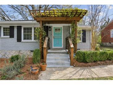 Charming home featuring a lovely gray brick, a light blue front door, and a vine-covered pergola at 2276 Scotty Cir, Decatur, GA 30032