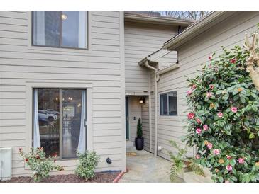 Inviting front entrance with neutral siding, blooming shrubs, and well-manicured landscaping at 3716 Stonewall Se Cir, Atlanta, GA 30339