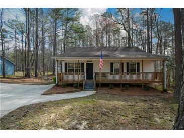 Charming cottage-style home featuring a welcoming front porch and an American flag at 98 Brenda Cir, Rockmart, GA 30153