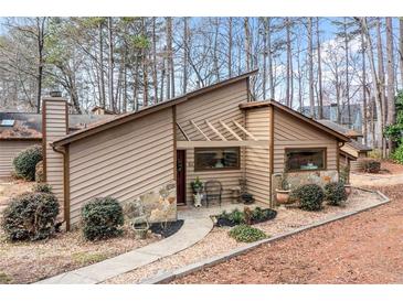 Charming home with wood siding, stone accents and professional landscaping with a winding walkway to the covered front entrance at 812 Bonnie Glen Se Dr, Marietta, GA 30067