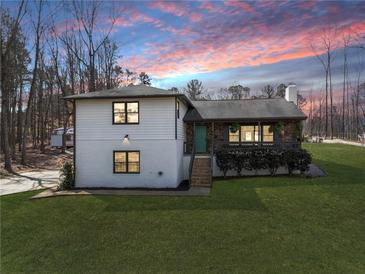 Charming two-story home with a stone accent wall, front porch, and beautiful landscaping, perfect for suburban living at 118 Raven Rd, Villa Rica, GA 30180