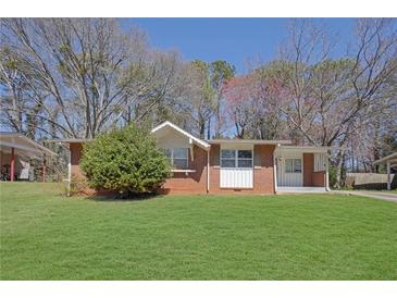 Charming single-story brick home featuring a well-manicured lawn and mature trees at 2522 Brentwood Ct, Decatur, GA 30032