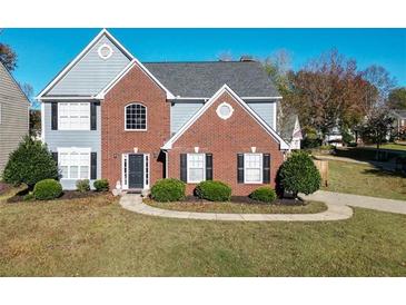 Charming two-story home with brick and siding, complemented by a well-manicured front yard and walkway at 3820 Mast Nw Ct, Kennesaw, GA 30144