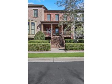 Charming brick townhouse featuring a welcoming front porch and meticulously landscaped yard at 3123 Neal Ct, Cumming, GA 30041