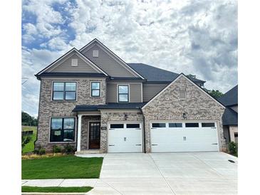 Beautiful two story home features a two-car garage and a well-manicured lawn at 4190 Hosch Reserve Dr, Buford, GA 30519