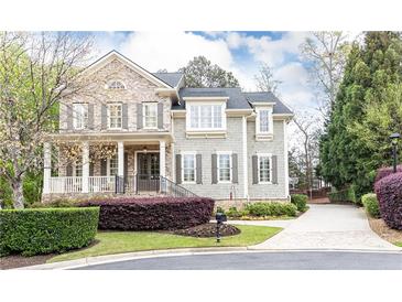 Charming two-story home with brick and shingle siding, landscaped yard, and a welcoming front porch at 570 Glengate Cv, Atlanta, GA 30328