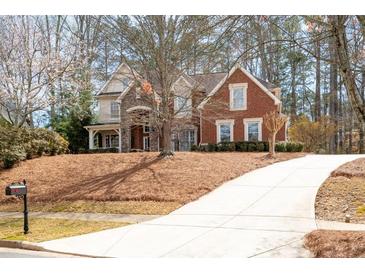 Charming two-story brick home with a long, inviting driveway surrounded by mature trees at 706 Registry Run, Kennesaw, GA 30152