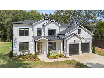 Charming new construction two-story home featuring white siding, black trim and a two-car garage at 396 Academy St, Alpharetta, GA 30009